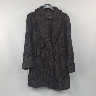 une photo d'un manteau noir accroché à un mur blanc