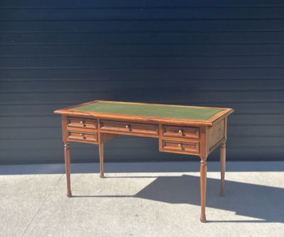 a small desk with two drawers and a green top