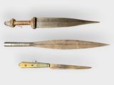 two old knives are sitting next to each other on a white surface