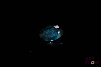 gros plan d'un diamant bleu sur une surface noire