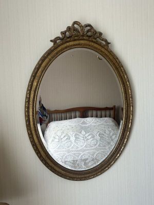 un miroir accroché au mur au-dessus d'un lit dans une chambre
