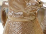 a brown vase with a dog on it sitting on a table