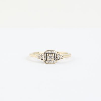 a yellow gold ring with a white diamond in the center
