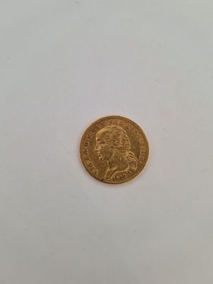 gros plan d'une pièce d'or sur une surface blanche