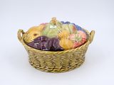 a wicker basket filled with assorted fruits on a white surface