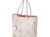 a white tote bag with holes and a red handle