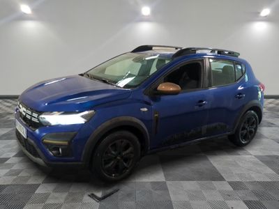 une voiture bleue est garée dans une pièce au sol à carreaux