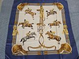 a blue table cloth with a picture of horses and jockeys on it