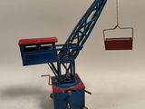 une grue miniature qui tient une boîte dans sa main