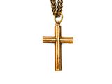 pendentif en forme de croix en or, suspendu à une chaîne en or, sur fond blanc