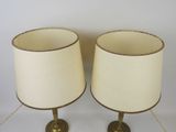 pair of brass table lamps with cream shades on bases