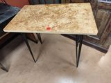 table en marbre avec des pieds en épingle à cheveux et un point rouge sur le plateau