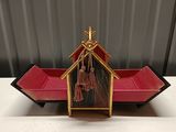 a small red boat with a gold roof and tassels on it
