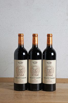trois bouteilles de vin posées sur une table en bois