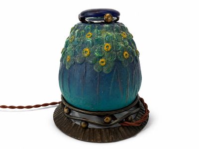 un vase bleu orné de fleurs jaunes, posé sur un socle