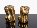 pair of gold colored salt and pepper shakers sitting on a black surface