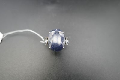 a close up of a ring with a blue stone on a black surface