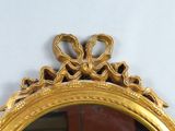 a mirror with a gold frame on the wall