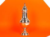 un fond orange sur lequel trône un vase argenté