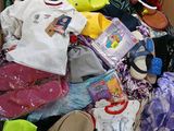 une boîte en carton remplie de vêtements pour bébé et d'autres articles