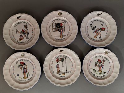 six assiettes blanches ornées de personnages de dessins animés, posées sur une table