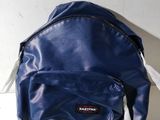 un gros plan d'un sac à dos bleu posé sur une surface blanche