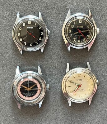 Quatre modèles de montres différents sont présentés sur un fond gris.