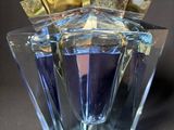 an image of a glass perfume bottle with a gold lid