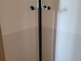 a black and silver coat stand in the corner of a room
