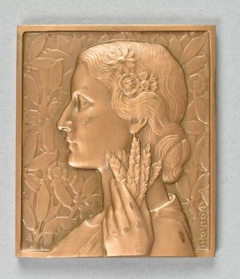 plaque en bronze représentant une femme avec une fleur dans les cheveux