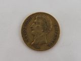 an old gold coin with a man ' s face on it