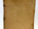 un vieux livre posé sur une table blanche, à côté d'une feuille de papier