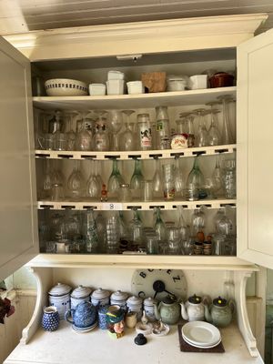 un placard rempli de vaisselle et de verres dans la cuisine