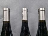 three bottles of wine that are sitting on a table