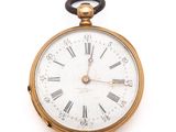 a gold pocket watch with roman numerals on the face