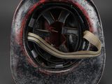 a close up of a red and black helmet with a white stripe
