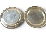 pair of silver plated dishes on a white surface with a white background