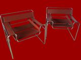 une paire de fauteuils de salon en chrome et en cuir sur fond rouge