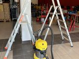 a yellow vacuum and some ladders in a room