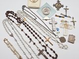un chapelet et d'autres objets religieux disposés sur une surface blanche