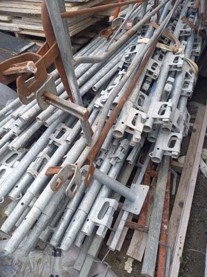 a large pile of metal pipes and poles in a yard