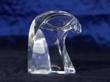 a clear glass sculpture of a bird on a black surface