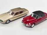 deux voitures jouets assises l'une à côté de l'autre sur une surface blanche