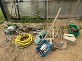 un tas d'outils de jardinage et d'autres outils par terre