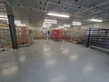 une grande pièce où se trouvent de nombreux rayonnages remplis de produits alimentaires