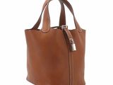 a brown leather tote bag with a zipper on the front