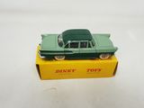 green toy car sitting on top of a yellow box on a white surface