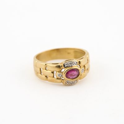 gros plan d'une bague en or avec un rubis et des diamants