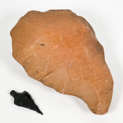 a rock and a black object on a white surface