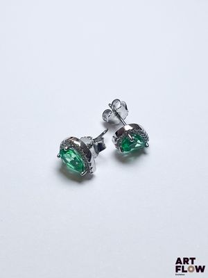 une paire de boucles d'oreilles en cristal vert sur fond blanc